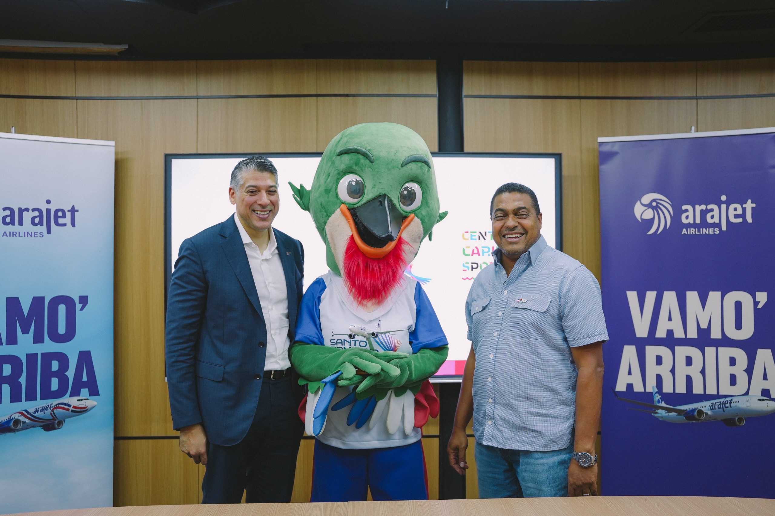 Víctor Pacheco Méndez y José P. Monegro junto a Colí, la mascota oficial de los Juegos Santo Domingo 2026.
